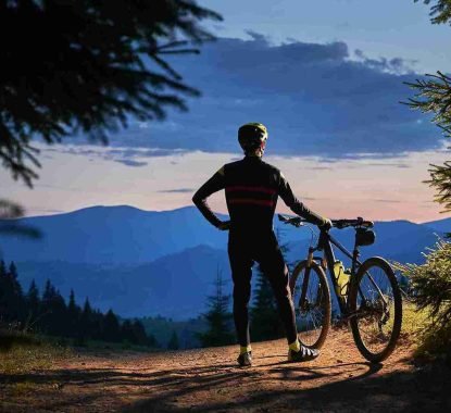 young-man-with-bike-enjoying-sunset-mountains_11zon